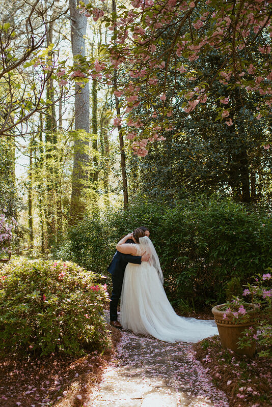 bride and groom hugging in middle of garden