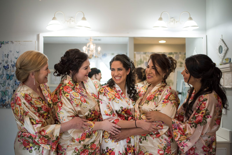 bride and bridesmaids wearing champagne-colored floral getting ready robes in farmhouse bridal suite