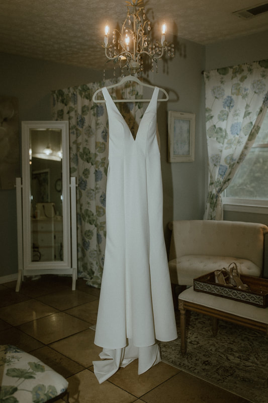 bride's dress hanging in neutral floral bridal suite