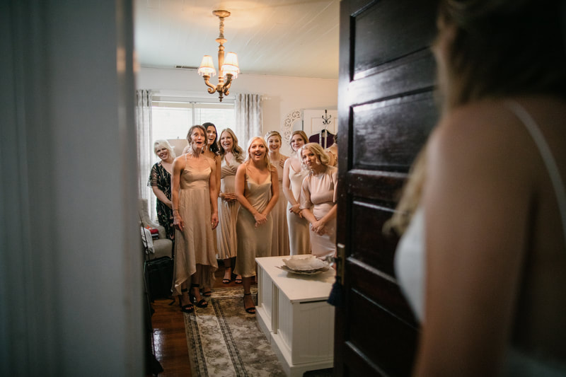 bridesmaids in champagne dresses during bride's reveal