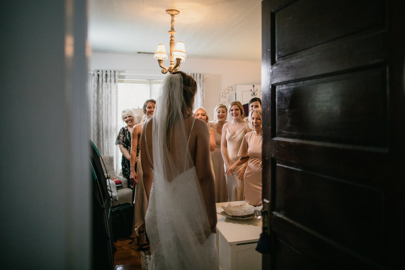bride in bridal suite for first look with bridesmaids