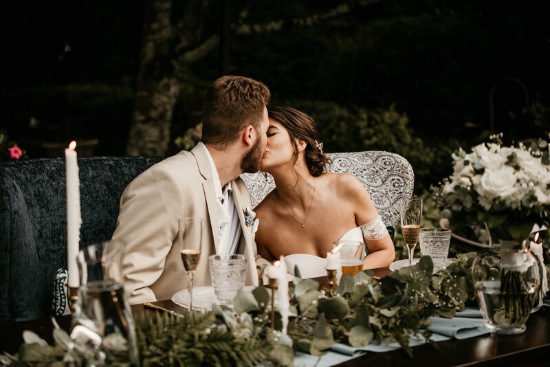 newlyweds sharing kiss at head table