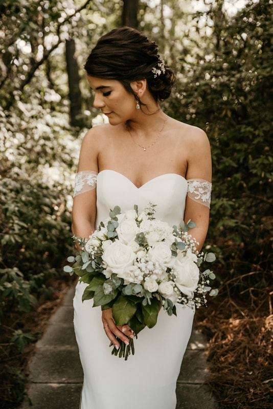 bride posing with white and green bridal bouquet by Karen and Laurens