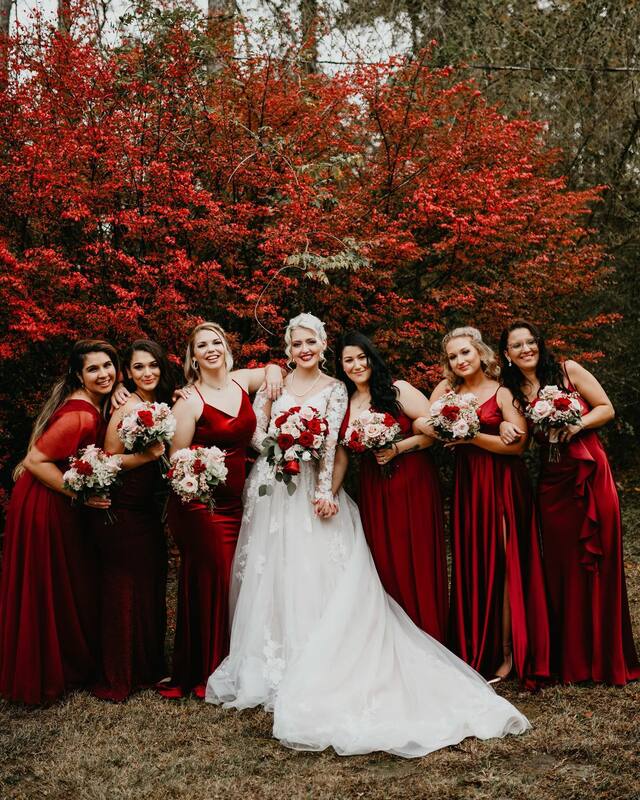 bride with bridesmaids in deep red dresses by red tree