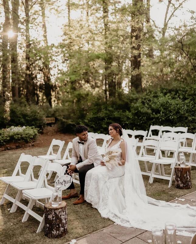 bride and groom sitting in outdoor ceremony chairs 