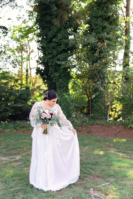 bride in long-sleeve dress posing in garden venue