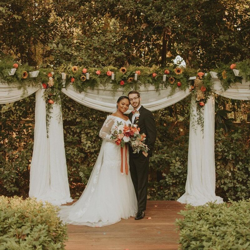 bride and groom at outdoor warm-toned fall altar