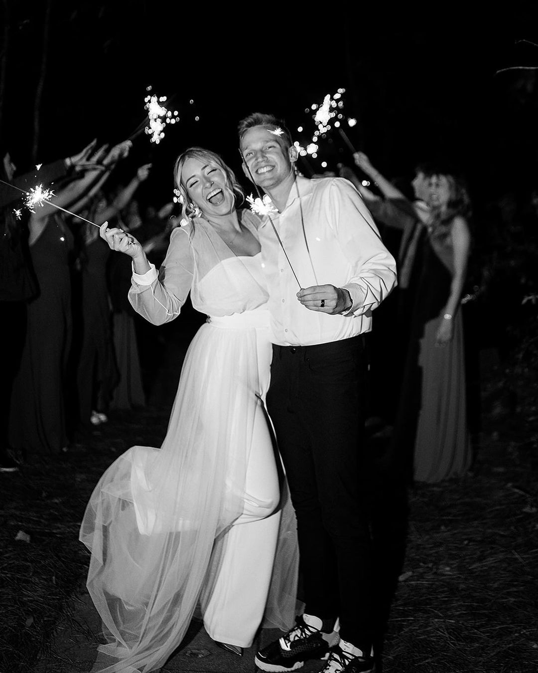 black and white photo of bride and groom holding sparklers during grand exit