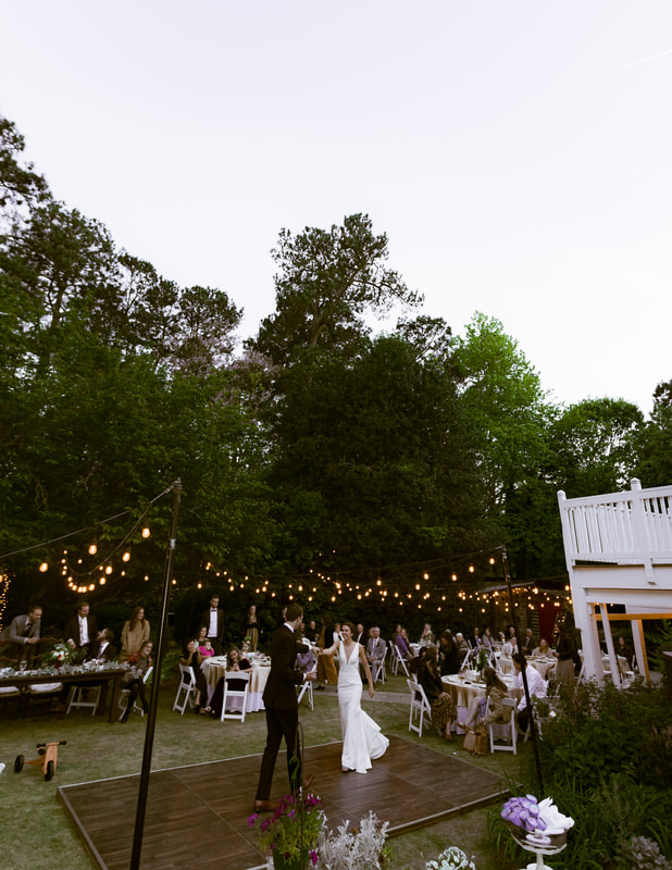 bride and groom's first dance on outdoor dance floor in garden reception venue