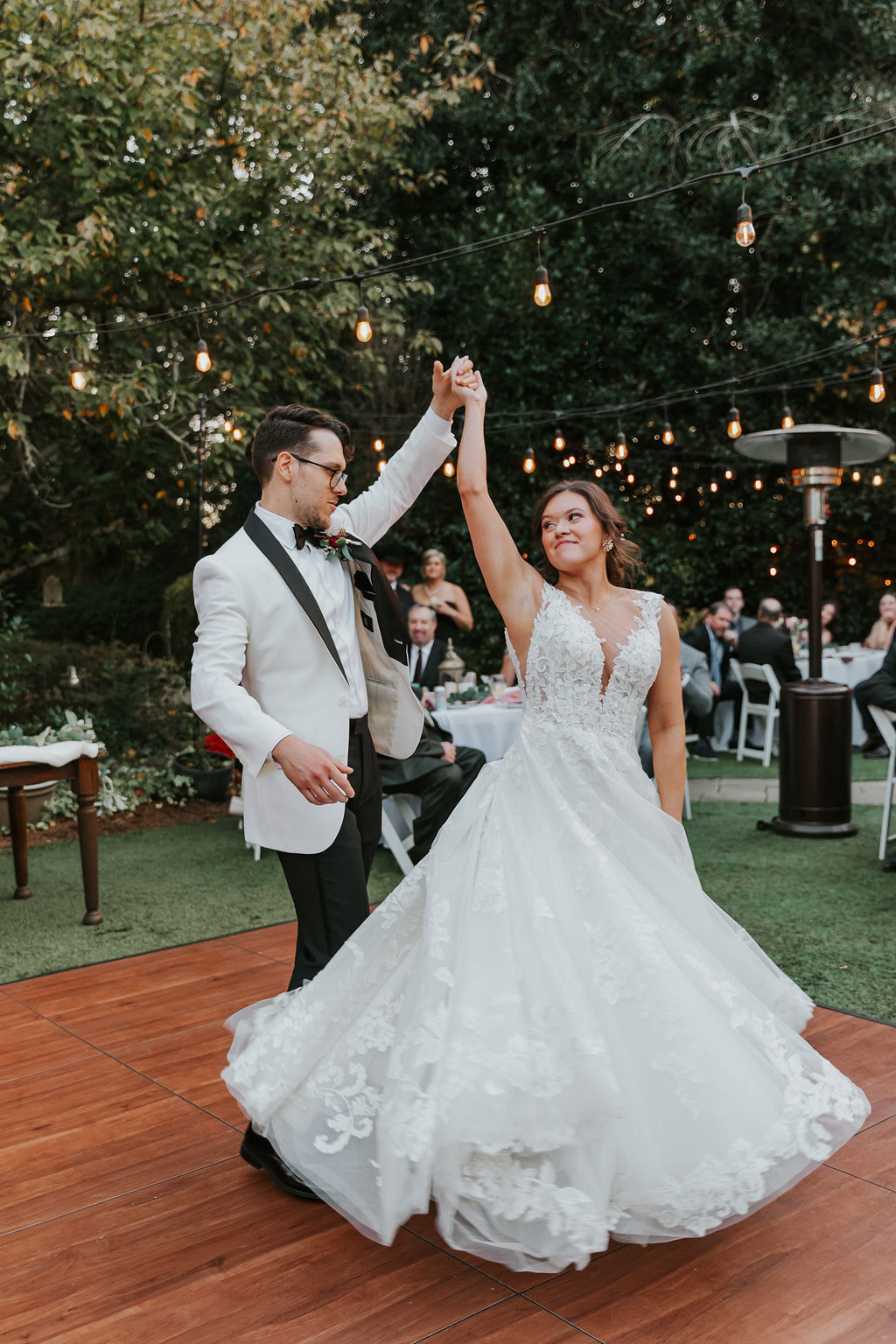 groom twirling bride on outdoor dance floor