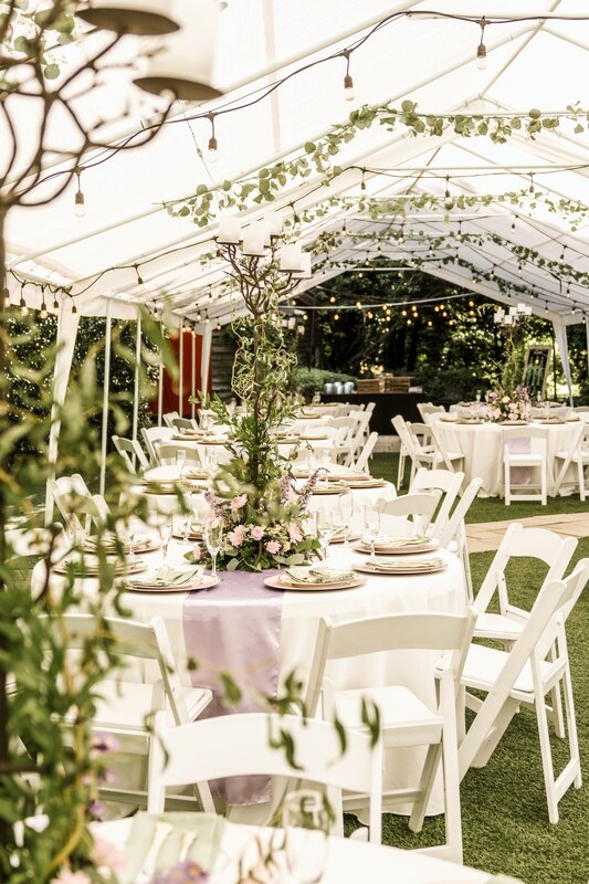 tented woodsy and whimsical wedding reception with sage green and lavender decor