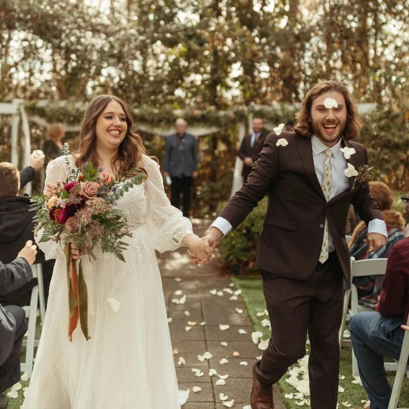 bride and groom recessing as guests toss petals