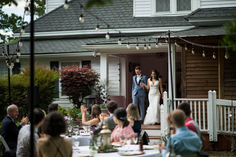 bride and groom announcement into outdoor reception from farmhouse porch