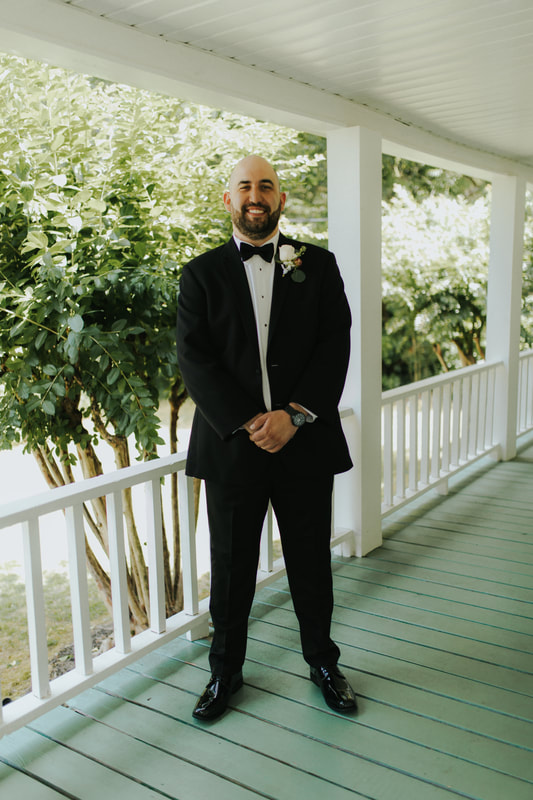 groom on farmhouse front porch