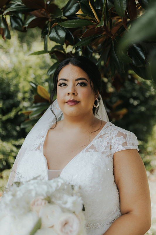 bride with lace dress posing by magnolia tree