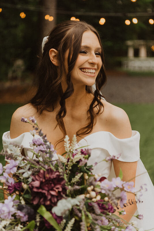 bride smiling with lavender and greenery bouquet