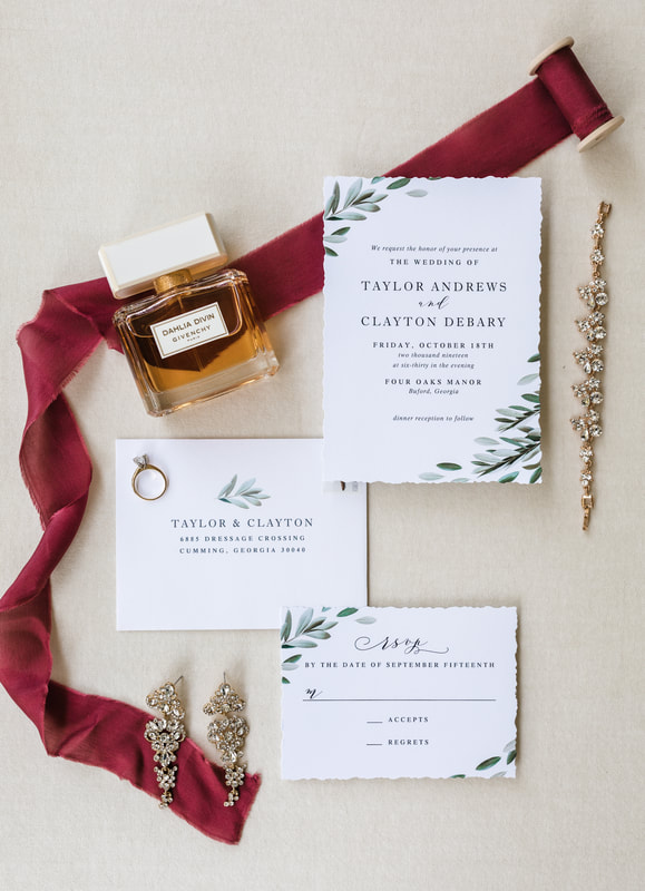 flatlay of white and greenery invitation suite