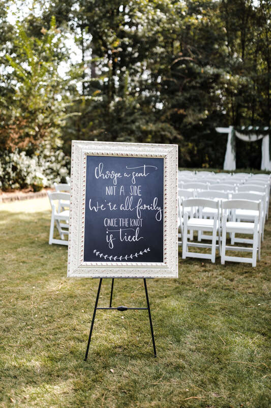 "Choose a Seat Not a Side. We're All Family Once the Knot is Tied" white chalkboard sign