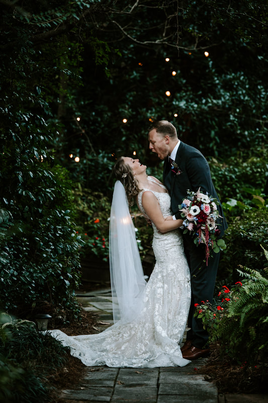 bride and groom laughing in garden path