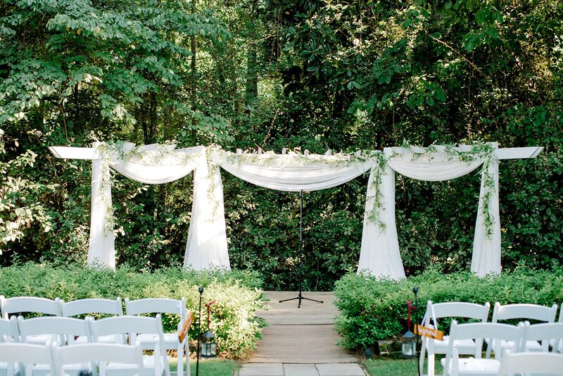 simple summer arbor decor with white chiffon and hanging greenery