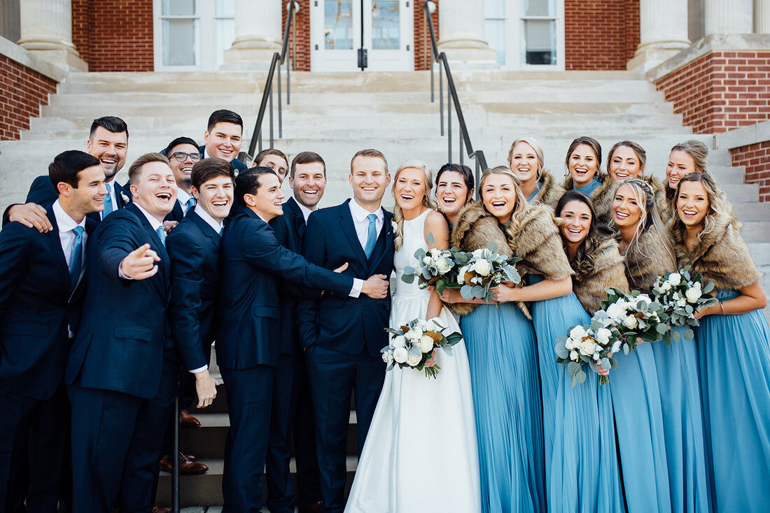 dusty blue wedding party in group hug on front steps