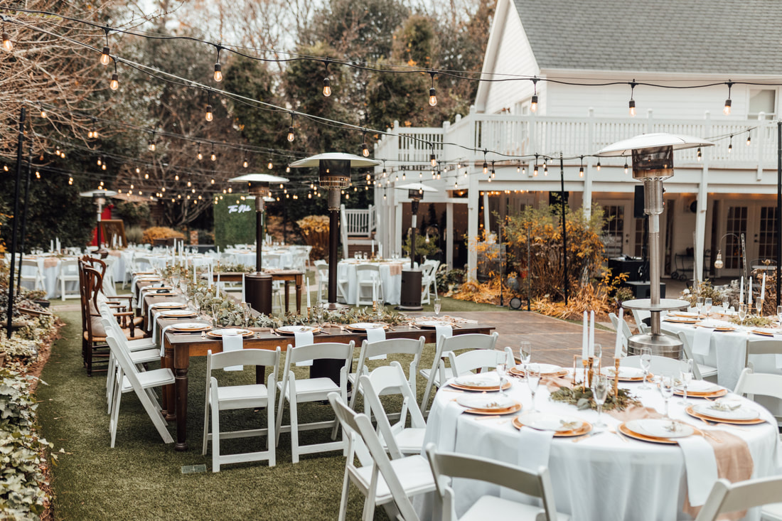 outdoor garden winter wedding reception with dance floor, head farm table, and bistro lights