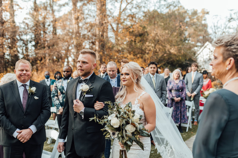 bride walking with brother down aisle during winter garden ceremony