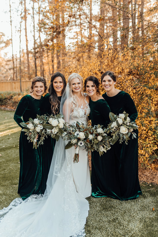 bride and bridesmaids posing by bush with yellow leaves