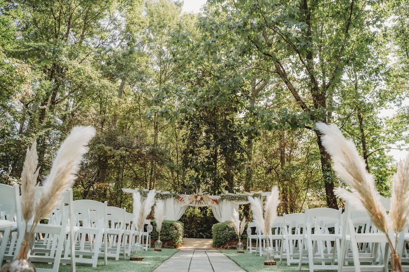 Boho wedding ceremony with pampas grass pews and arrangement on the altar