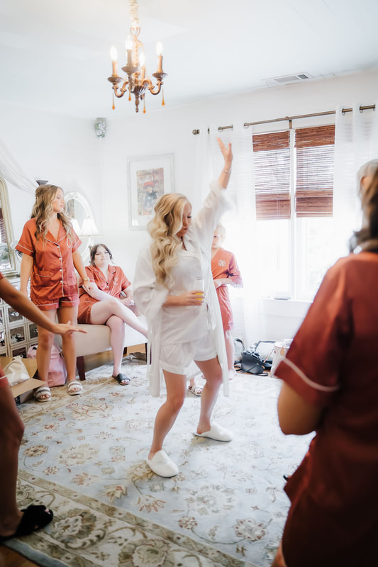 Bride dancing with her bridesmaids in the getting ready suite