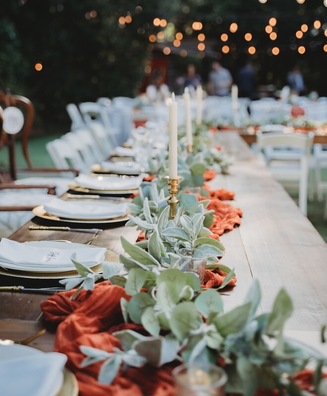 Farmtable head table with terracotta cheese cloth runners, gold candlesticks & tapered candles