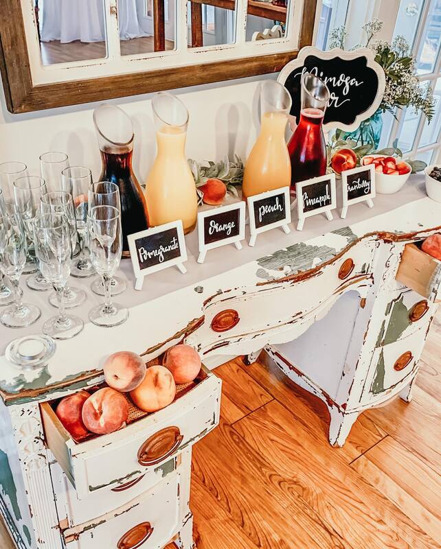 mimosa bar with various juices on vintage white desk filled with peaches
