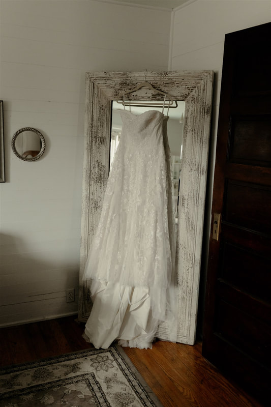 strapless wedding dress hanging on tall mirror
