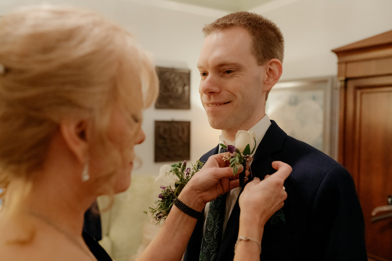 mother pinning boutonniere on son