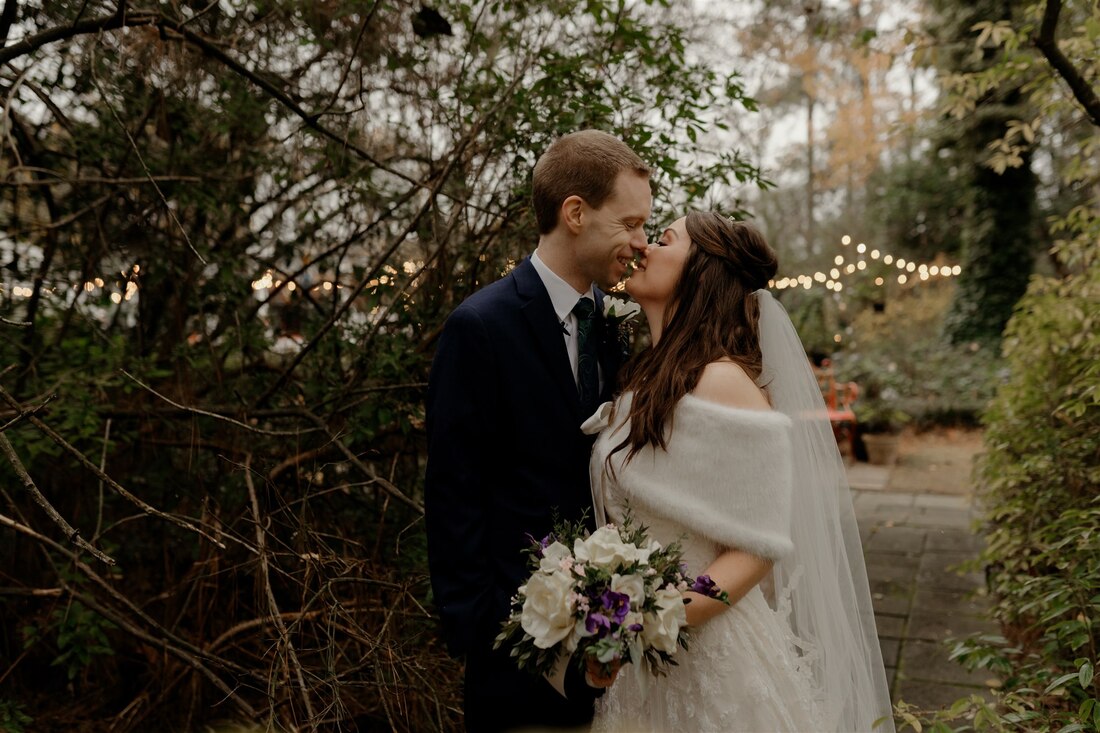 bride and groom kissing in garden path