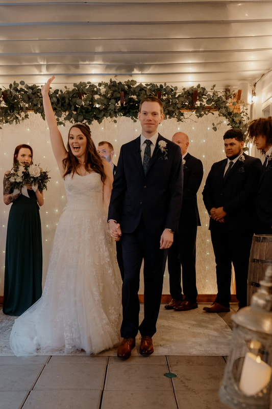 bride holding arm up in celebration after ceremony