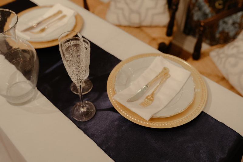 gold place settings on white and navy table
