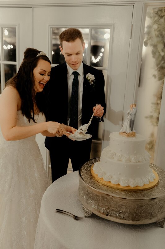 bride laughing during cake cutting with groom