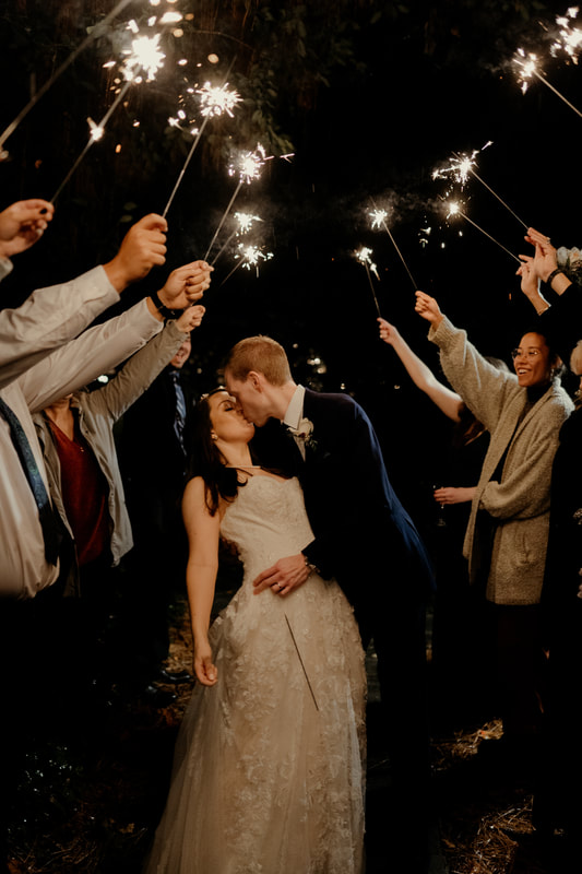 bride and groom kissing during sparkler grand exit