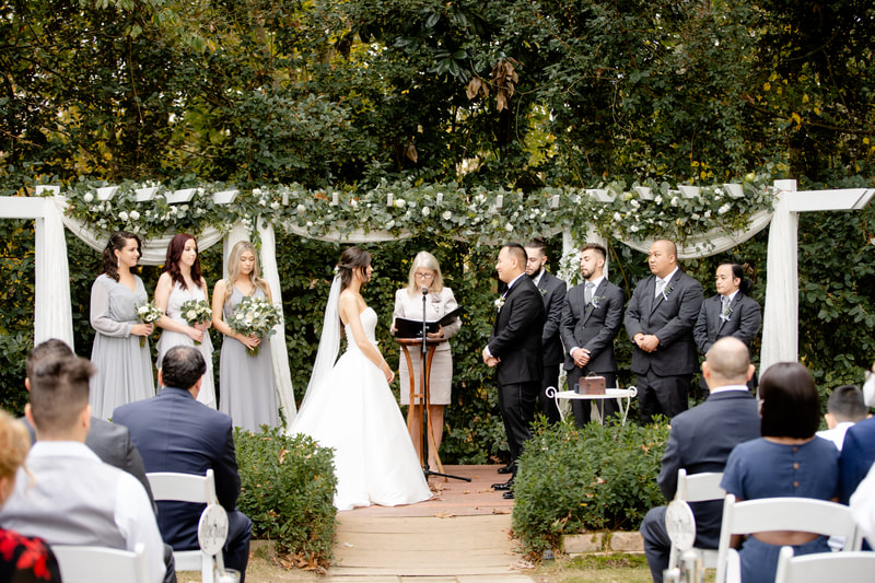 neutral fall wedding ceremony with greenery decorated altar