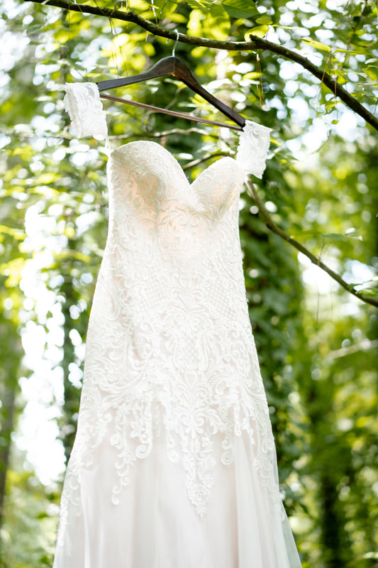 lace dress with sweetheart neckline hanging on tree branch