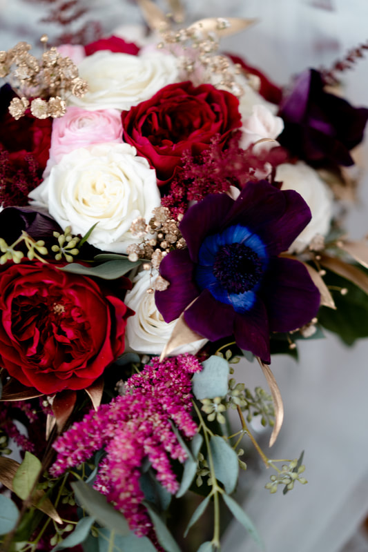 closeup of bridal bouquet with eucalyptus, amaranth, anenome, and roses