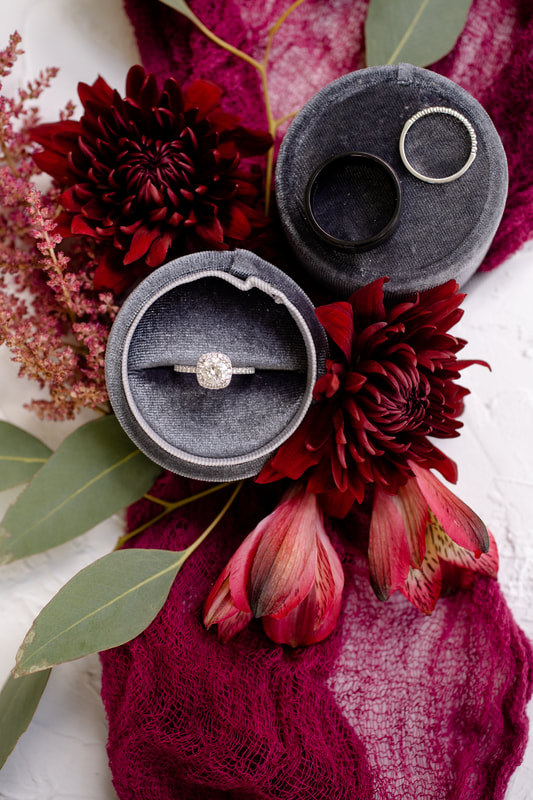 engagement and wedding rings in gray velvet ring box with burgundy floral details