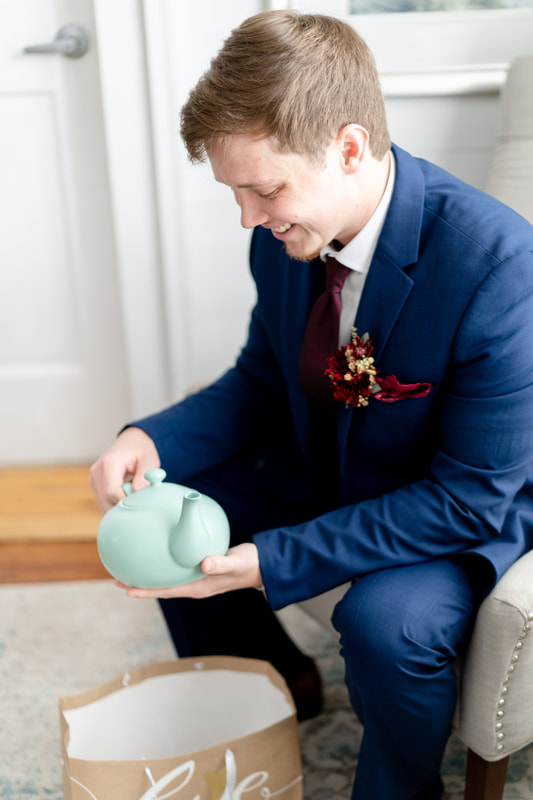groom opening gift from bride with teapot similar to the one from "The Office"