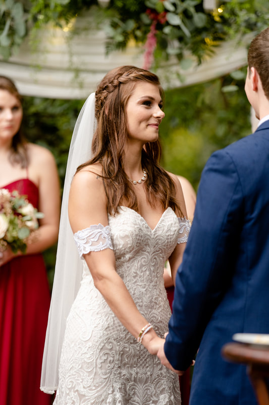 bride smiles at groom during outdoor ceremony in september