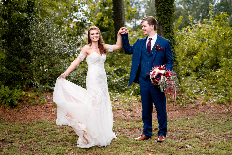 groom holding bride's bouquet and hand as she twirls