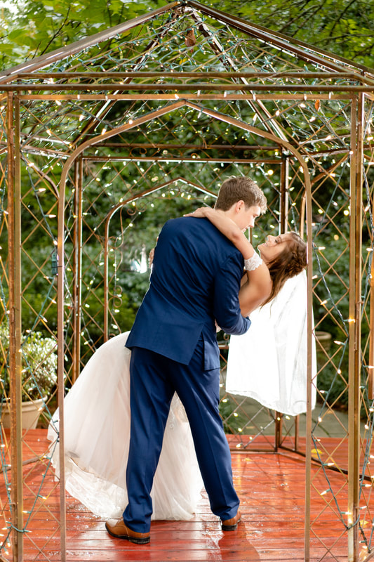 groom dipping bride during first dance under the gazebo