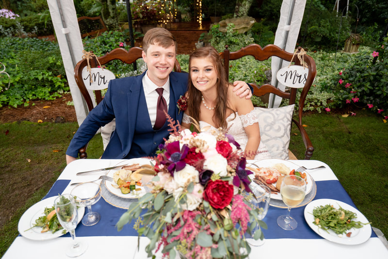 couple sitting at head table with mr. and mrs. chairs
