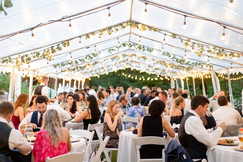 guests eating dinner at tented wedding reception