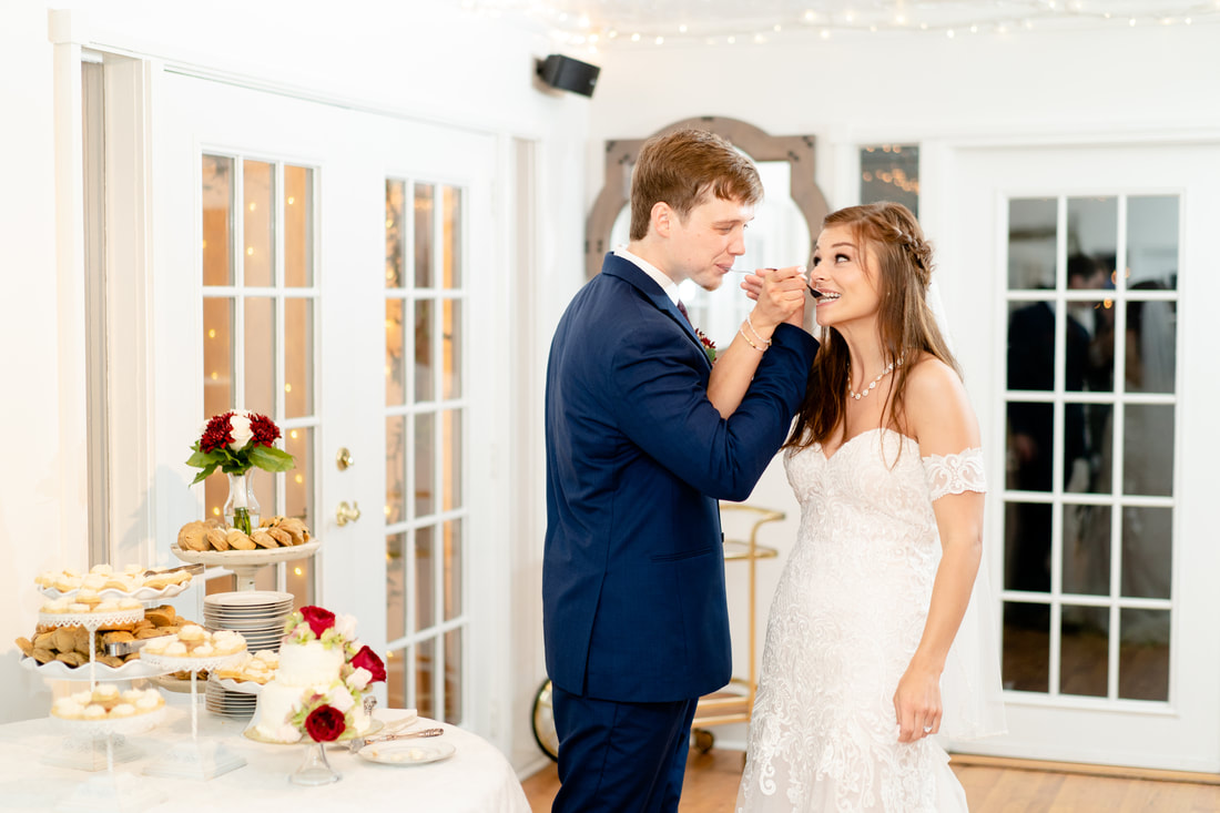 couple feeding each other wedding cake inside the carriage house
